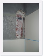 IMGP0997 * Dit is de andere zijde van de muur waar de trap tegen staat, een middag later. Ondanks herhaaldelijk vermelden dat er buizen aan de andere kant van de muur ingewerkt waren, is de aannemer er toch in geslaagd om dwars door de muur en in de muurverwarming te boren :-( 
Resultaat: voegen uitkrabben, muurtegels weer openbreken, muurpleister wegkappen om de buis bloot te leggen. Donderdag wordt de buis normaal weer in de oorspronkelijke staat hersteld...